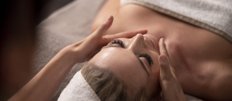 giovane-donna-che-massaggia-il-viso-del-suo-cliente